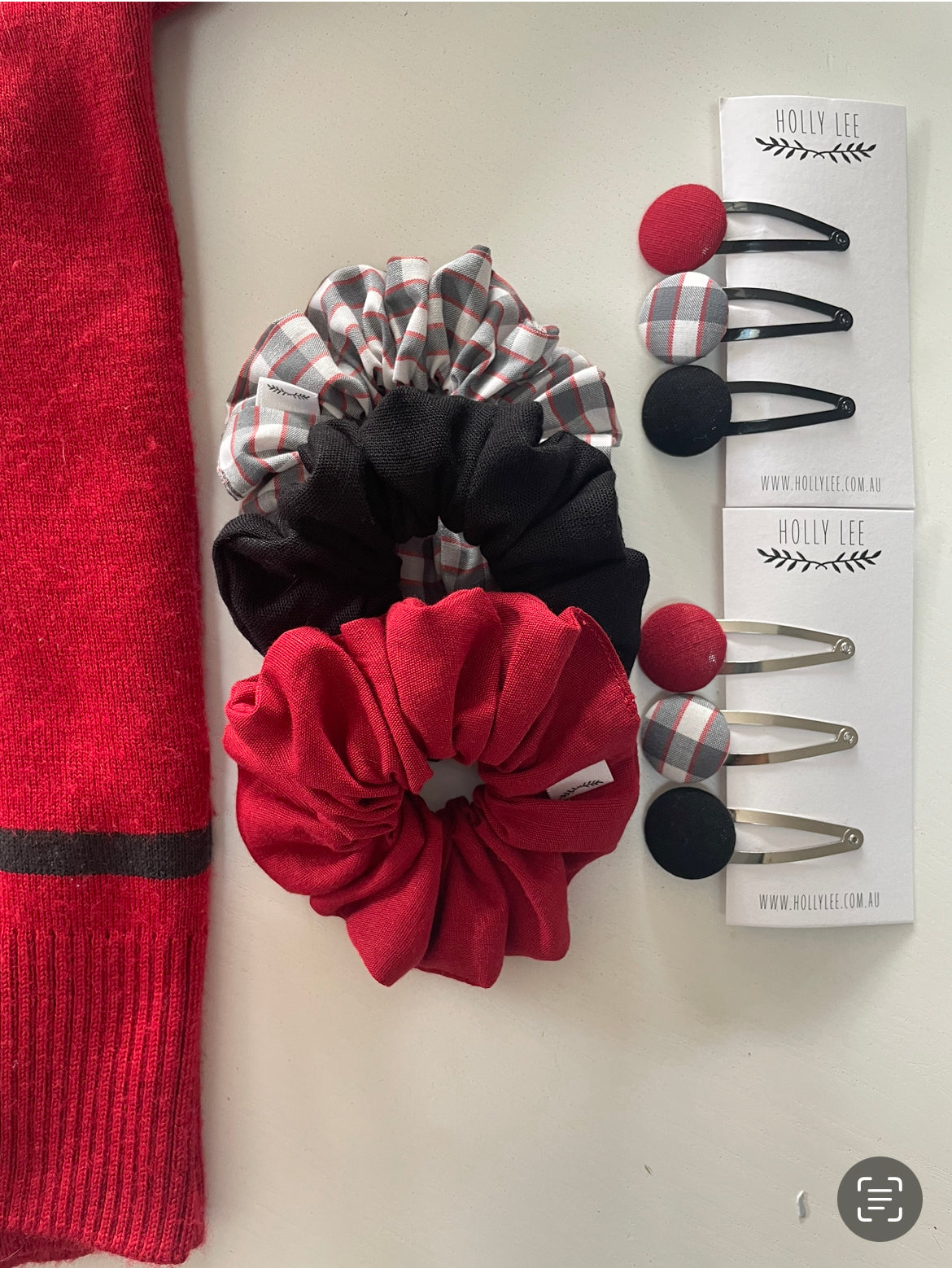 Red, black and grey check scrunchies pictured beside coordinating snap hair clips